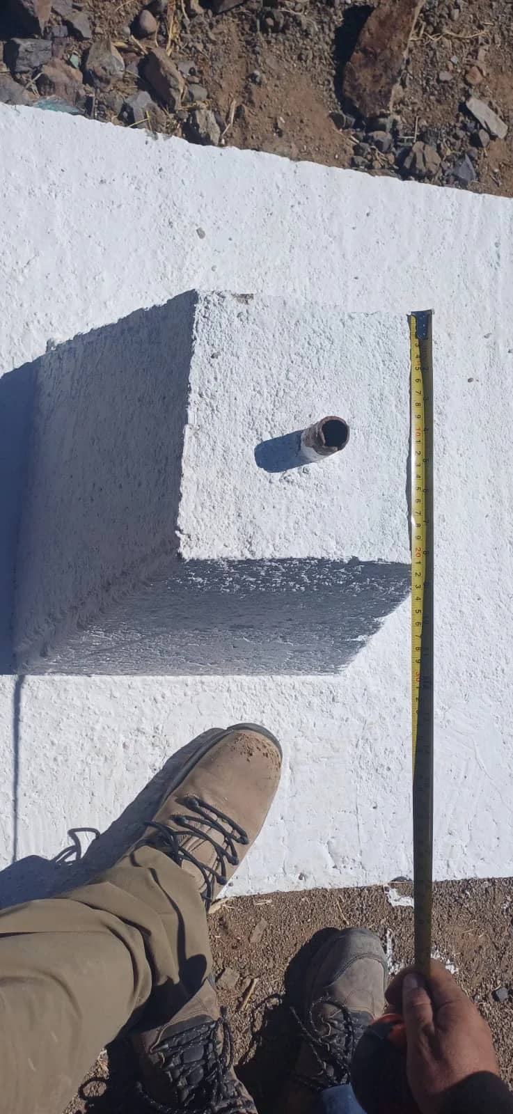 Topógrafo de GEO CORS midiendo hito de mensura HM Guadalupe III con huincha certificada sobre monolito de hormigón en Vallenar