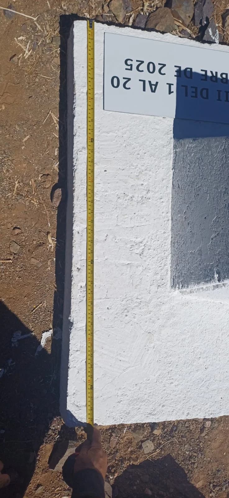 Medición lateral de monolito Guadalupe III con huincha extendida sobre la superficie